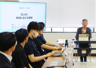写真：若手職員にＤＸについて説明する大野氏（右）