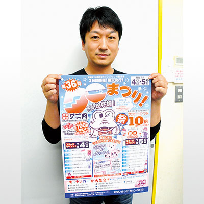 写真：ポスターを手に来場を呼びかける荒井実行委員長