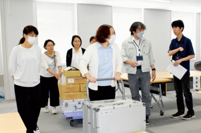 写真：投票用紙を運ぶ管内自治体の担当者＝２３日午後３時半ごろ
