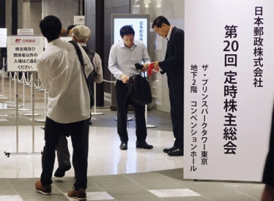 写真：日本郵政の株主総会に向かう株主ら＝２５日午前、東京都内