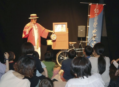 写真：大阪市阿倍野区で開かれた公演で紙芝居を披露する岩橋範季さん＝６月