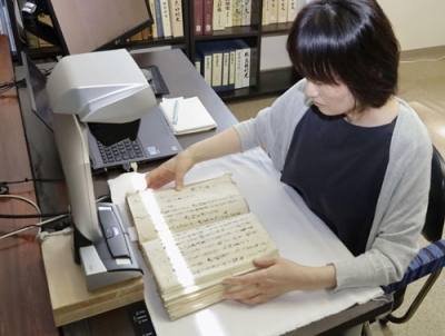 写真：古文書をスキャンして画像にする作業＝６月、富山県南砺市の善徳寺
