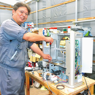 写真：資格を持つ確かな技術でストーブを分解掃除する中山代表