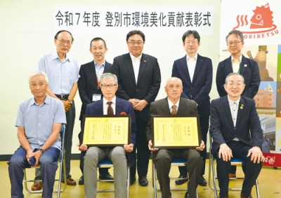 写真：表彰された吉田さん（前列右から２人目）、奥寺さん（同３人目）と関係者