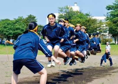 写真：息を合わせ長縄を跳ぶ生徒たち