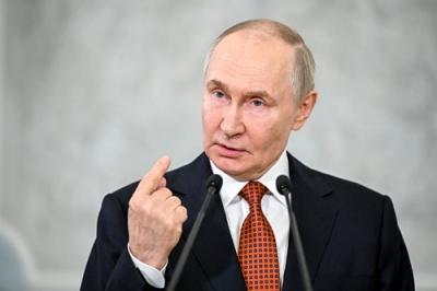写真：２７日、ベラルーシの首都ミンスクで記者団の質問に答えるロシアのプーチン大統領（タス＝共同）