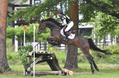 写真：クロスカントリーコースの障害物を跳び越える戸本一真選手と馬＝５月、山梨県北杜市の県馬術競技場