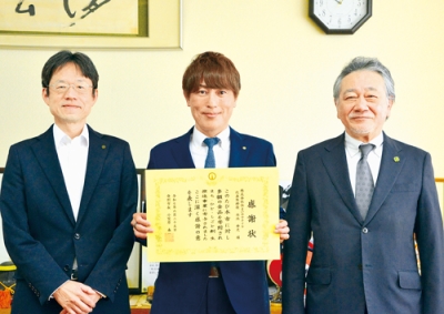 写真：登別市から感謝状を受けた内池代表取締役（中央）。右は仲川会長、左は千葉副市長