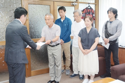 写真：大塩町長（左）に反対署名を手渡す地域住民