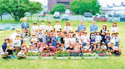 写真：花苗を前に笑顔を見せる室蘭美園幼稚園の園児と「小さな親切」運動のメンバー