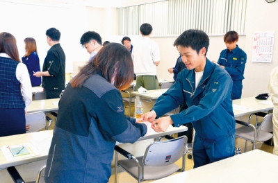 写真：名刺交換の正しい方法を学ぶ若手社員ら