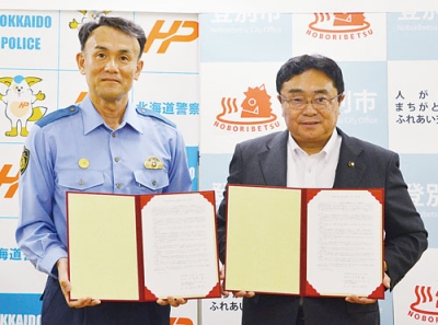 写真：協定を締結した小笠原市長（右）と堀江室蘭署長
