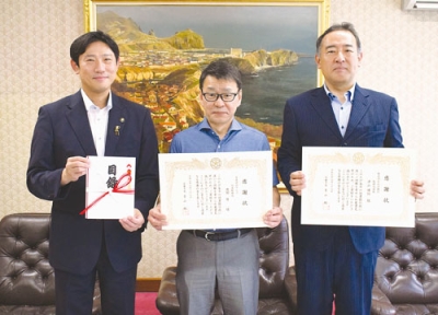 写真：室蘭市に図書カードを寄贈した（右から）赤保内支店長、渡部代表取締役