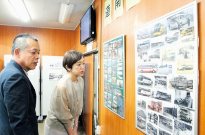 写真：パネル展で会社の足跡を紹介する長谷川社長（左）