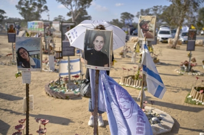 写真：２日、イスラエル南部レイムでの抗議活動で「即時停戦を」と記された傘を持つ女性（ＡＰ＝共同）