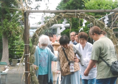 写真：無病息災を祈り茅の輪をくぐる町民ら（提供写真）