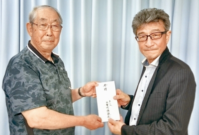 写真：千田理事長（左）に観戦チケットを贈る阿野会長（提供写真）