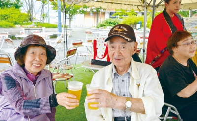 写真：雨でもテントの下で生ビールで乾杯する来場者