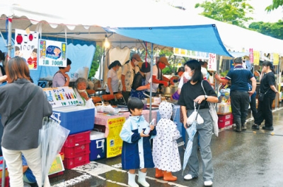 写真：雨の中でも露店街を楽しむ来場者