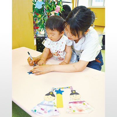 写真：短冊に願い事を書き込む親子