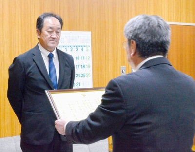 写真：安宅教育長から感謝状を受け取る芹川代表取締役（左）
