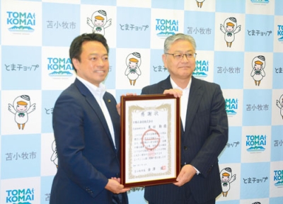 写真：金澤市長から感謝状を受けた栗田社長（右）