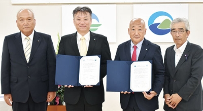 写真：友好都市提携５０周年確認書に署名した洞爺湖町の下道町長（右から２人目）と三豊市の山下市長（同３人目）