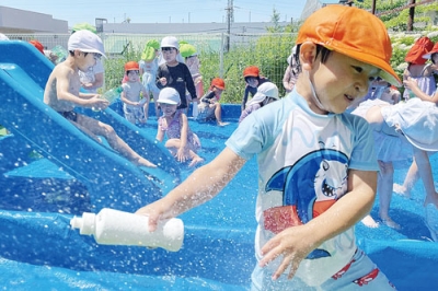 写真：今年初の真夏日に水遊びを楽しむ室蘭中島幼稚園の園児たち＝７日午前１０時５０分ごろ