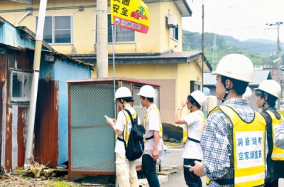 写真：虻田地区の空き家候補で実態調査を行う学生ら
