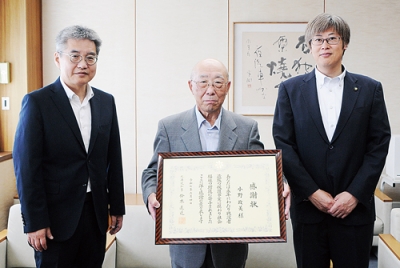 写真：感謝状を手にする小野さん（中央）