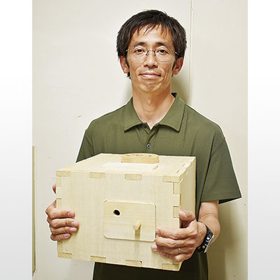 写真：生徒らと試作を重ねる「赤道儀」を手に、南極入りに備える宮川教諭