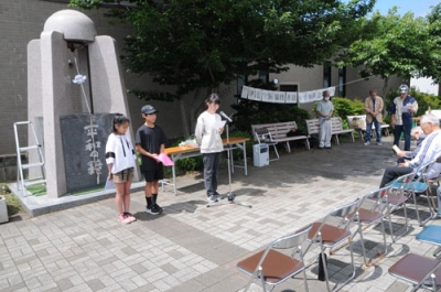 写真：「平和祈念の集い」で作文を読み上げる伊達小児童