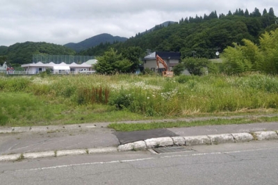 写真：男性が倒れていた草地。左奥はグループホーム＝１２日午前、福島町
