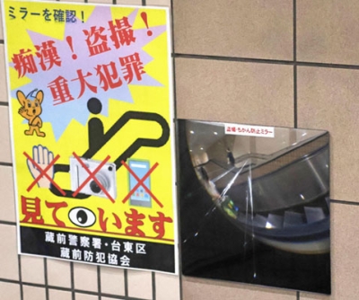 写真：駅のエスカレーター横の壁に設置された特殊な鏡＝６月、東京都台東区