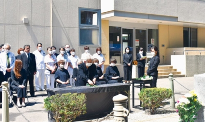 写真：空襲犠牲者に白菊を手向け冥福を祈る出席者