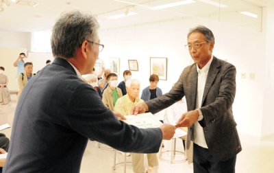 写真：室蘭市長賞の表彰状を受け取る羽山さん（右）