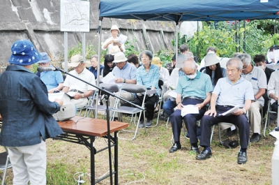 写真：犠牲者の名前を読み上げ追悼する参列者＝１５日、海岸町の憲法九条の碑前広場