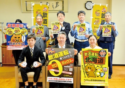 写真：飲食店関係団体に贈られた啓発資材を持つ出席者ら