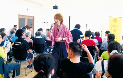 写真：ライブで楽曲を披露する松尾さん