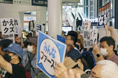 写真：参院選候補者の街頭演説に対し「差別をやめろ」と抗議する人たち＝１２日、川崎市