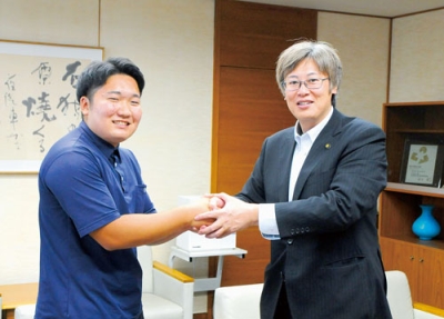 写真：堀井市長と握手を交わす佐藤さん
