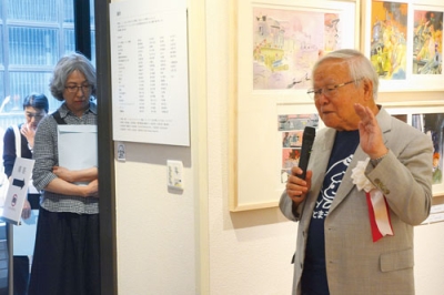 写真：展示について解説する安彦さん（右）
