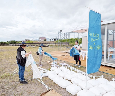 写真：設営作業が進む海の家の会場＝１８日