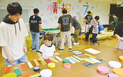 写真：色に反応して音が出る電子楽器を体験する来場者