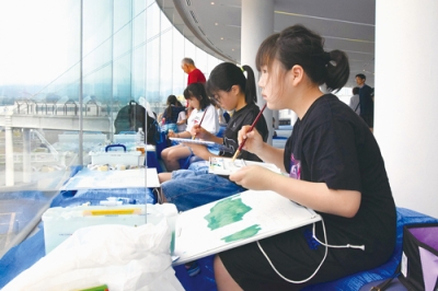 写真：画用紙に港の景色を描く子どもたち