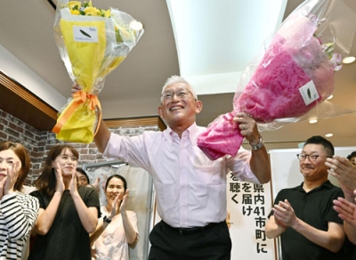 写真：兵庫選挙区で当選を決め、花束を手に笑顔の泉房穂氏＝２０日夜、神戸市中央区