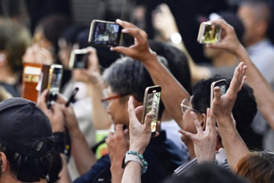 写真：参院選の候補者らの街頭演説をスマートフォンで撮影する人たち＝１９日、札幌市