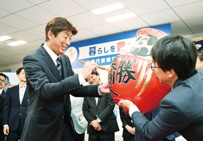 写真：だるまに墨を入れて当選を喜ぶ岩本さん＝２１日午前２時４５分、札幌市中央区の選対事務所