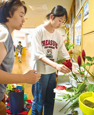 写真：ロビーを生け花で彩る児童ら