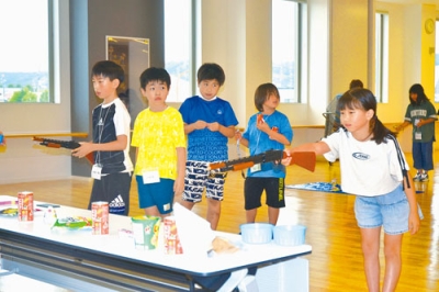 写真：縁日コーナーの射的を楽しむ子どもたち